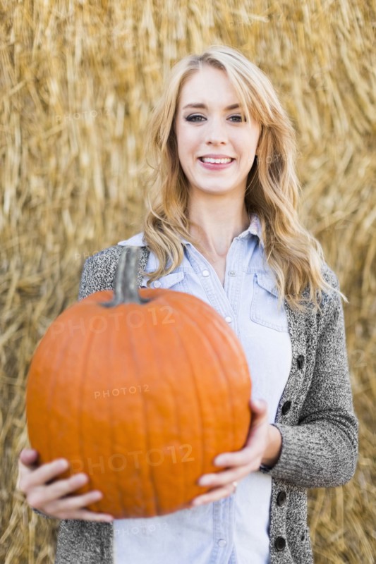 Portrait of young woman holding pumpkin