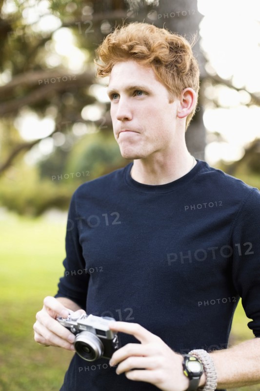 Portrait of young man holding camera