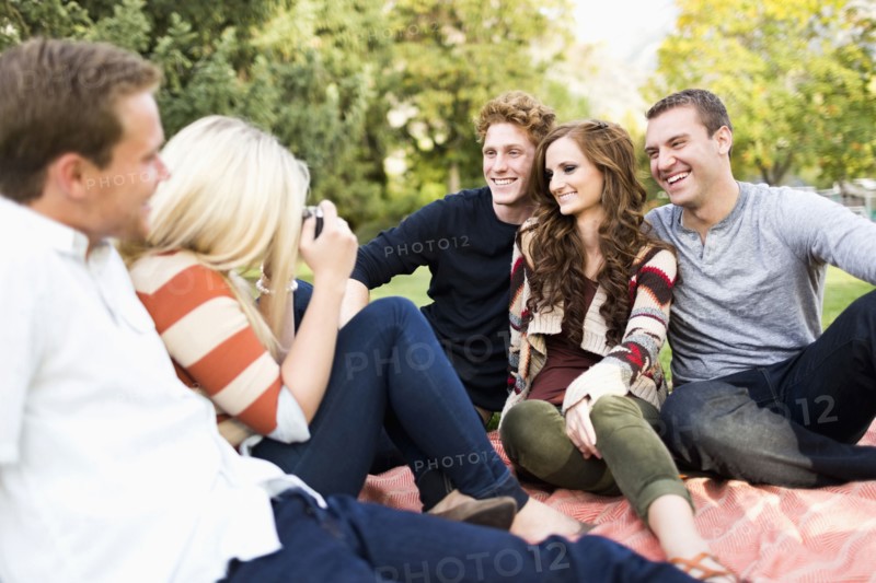 Group of friends taking photos in park