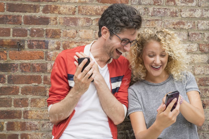 Couple sharing messages on cell phones.