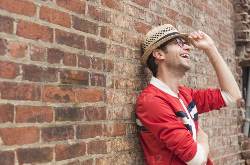 Portrait of mid adult man in front of brick wall.