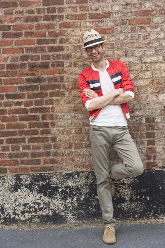 Portrait of mid adult man in front of brick wall.