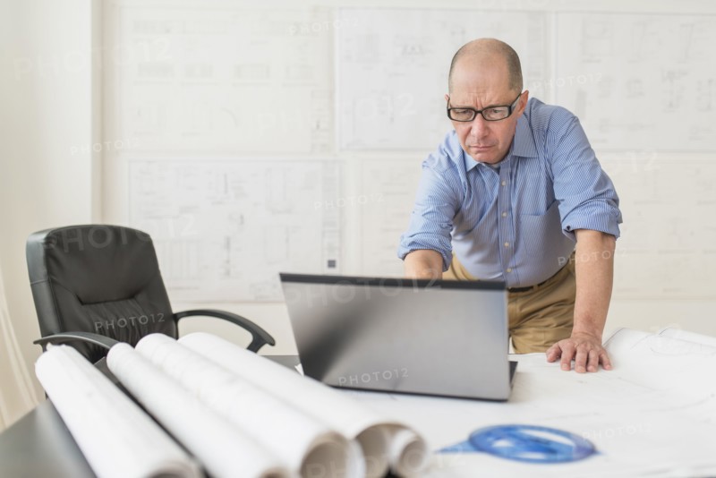 Mature architect using laptop in office.