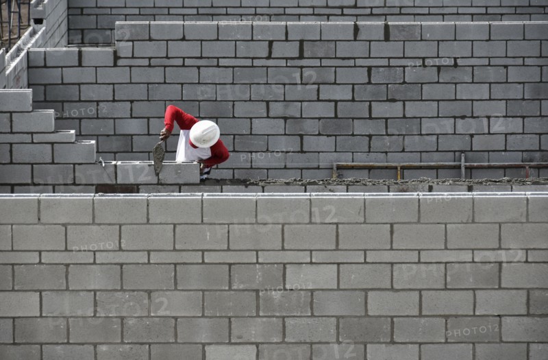 Bricklayer working on brick wall.