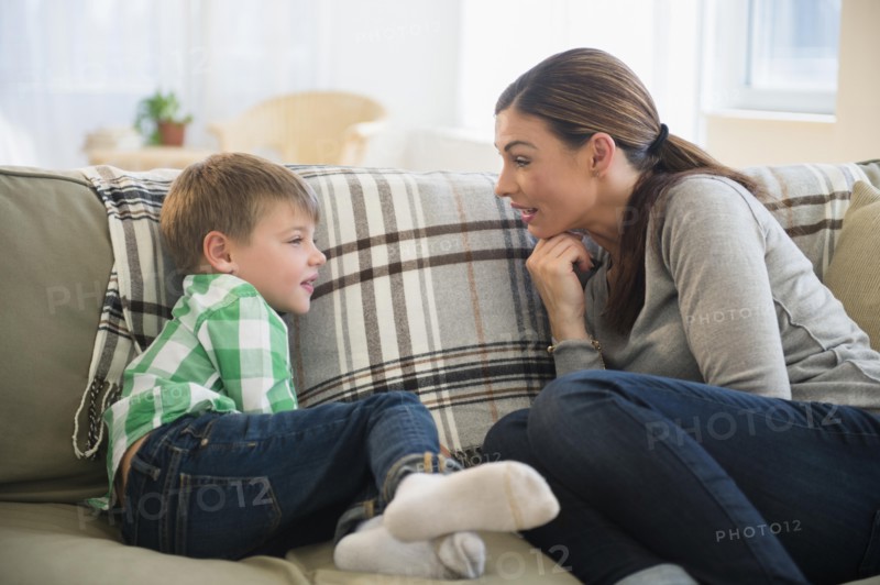 Mother and son (6-7) sitting on sofa