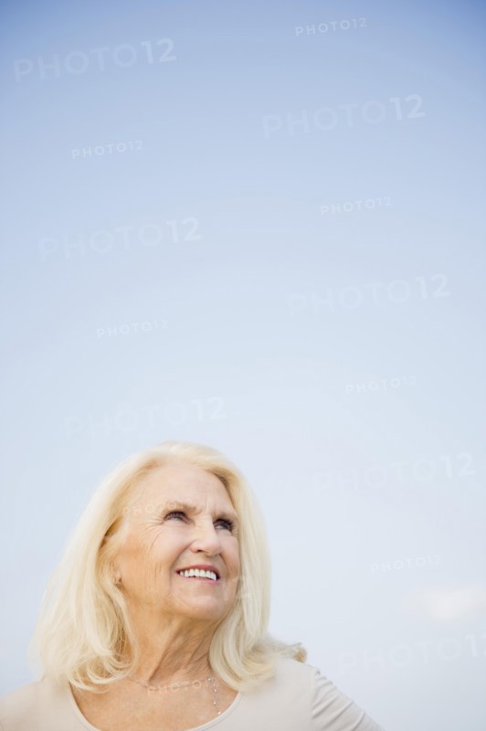 Portrait of senior woman against blue sky