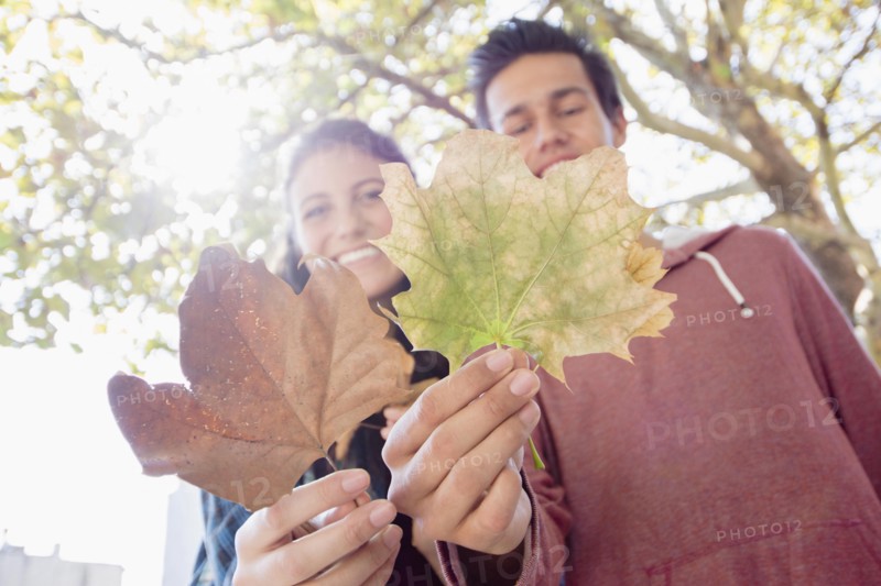 Portrait of young couple showing leaves