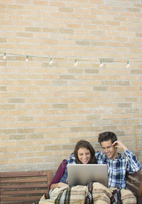 Young couple using laptop on roof