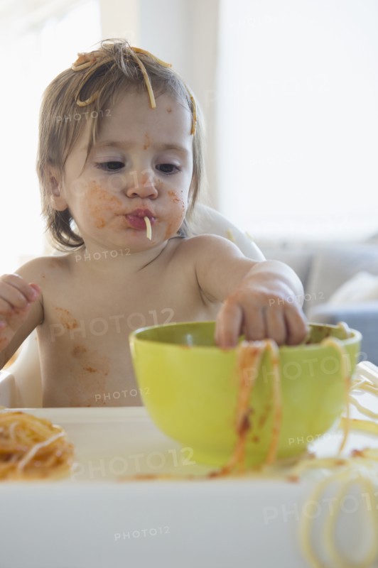 Girl (2-3) eating spaghetti