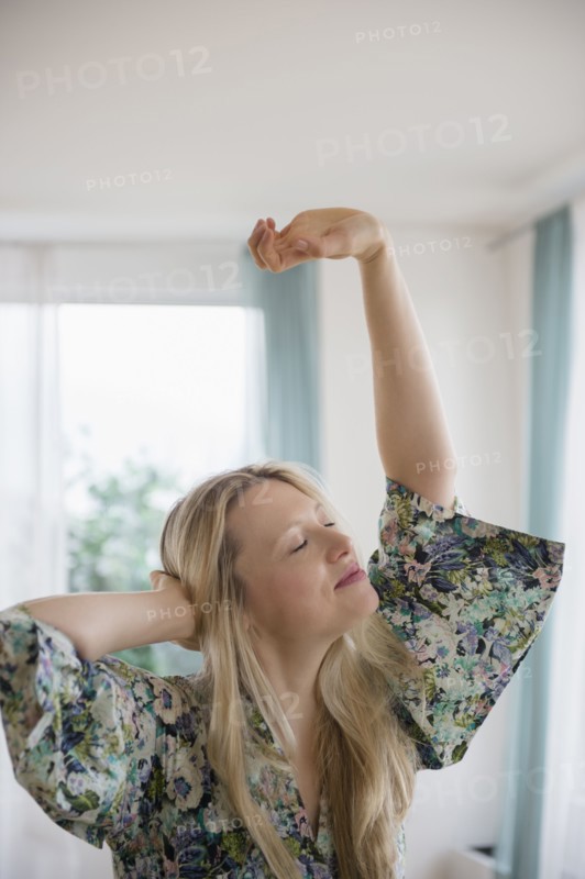 Blond woman stretching at home