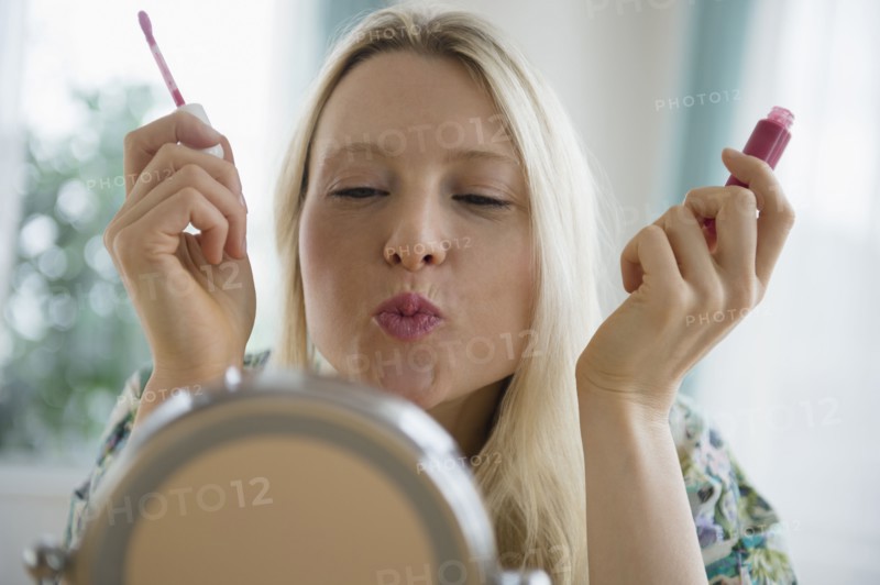 Woman applying lipgloss