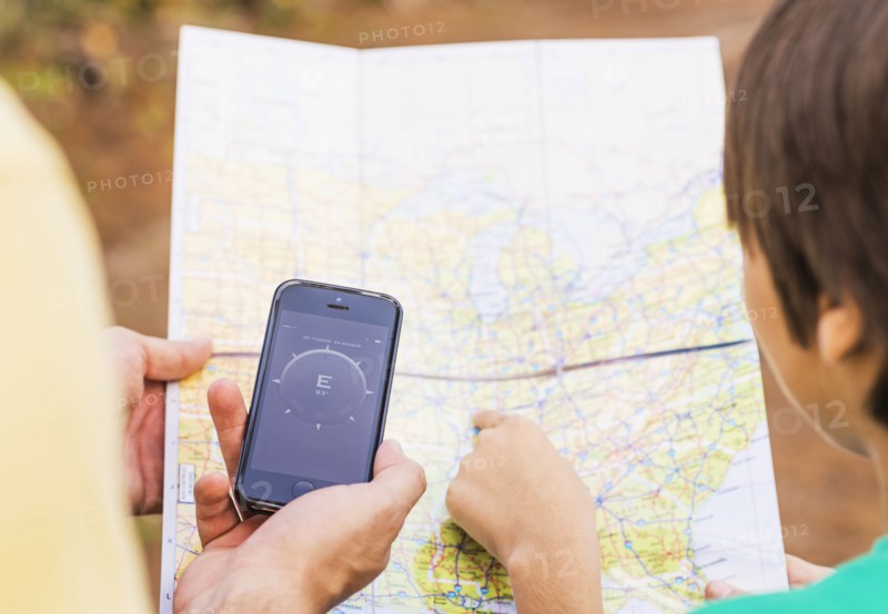 Father and son (12-13) using smartphone app and map