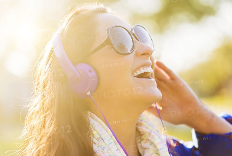 Woman in sunglasses and headphones outdoors