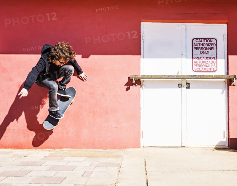Man skating near red wall