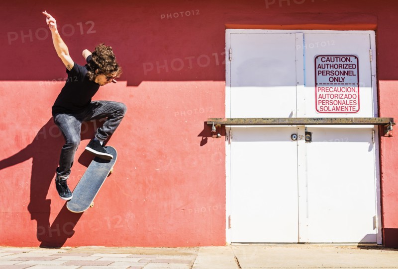 Man skating near red wall
