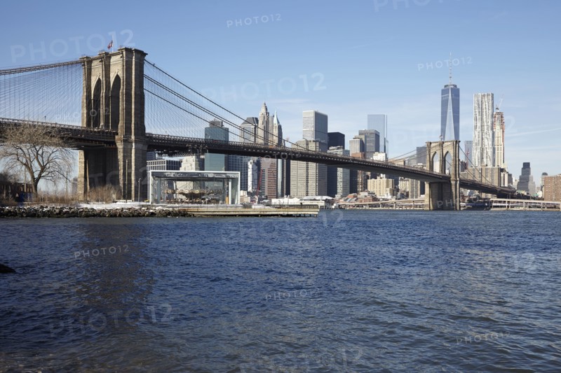 View of waterfront cityscape with suspension bridge