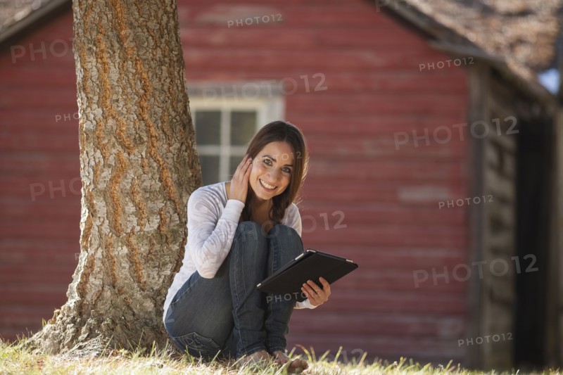Portrait of woman sitting outdoors with tablet