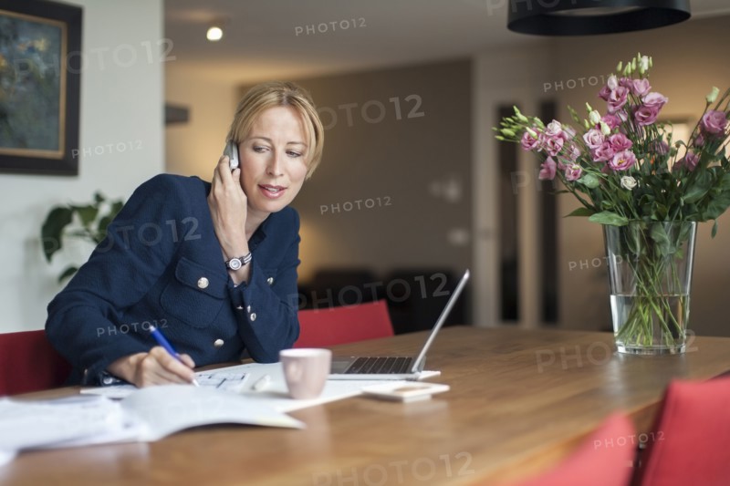 Woman talking on phone and making notes