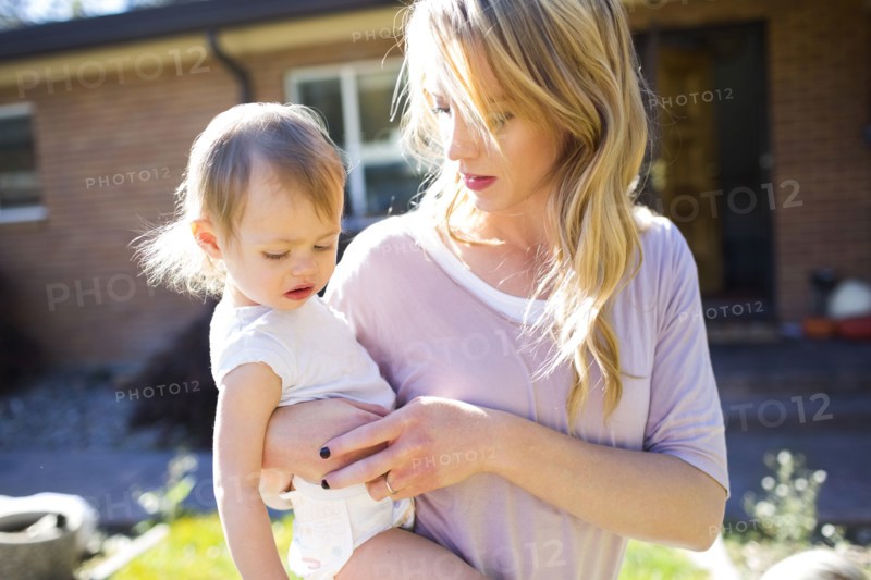 Mother and daughter (12-17 months) in backyard
