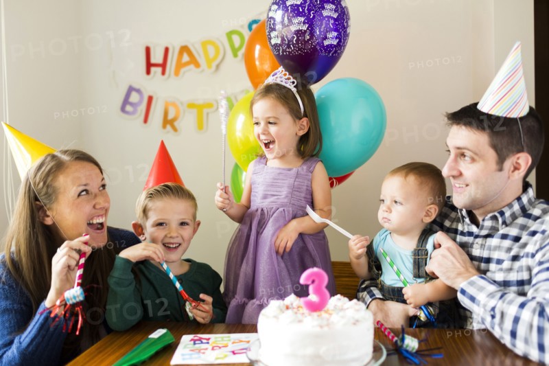 Family with three children (2-3, 4-5) celebrating birthday