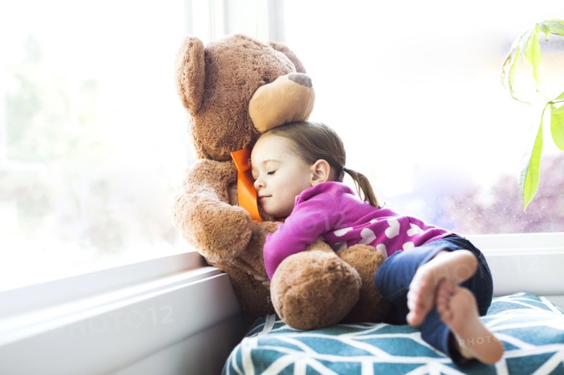 Girl (4-5) embracing teddy bear
