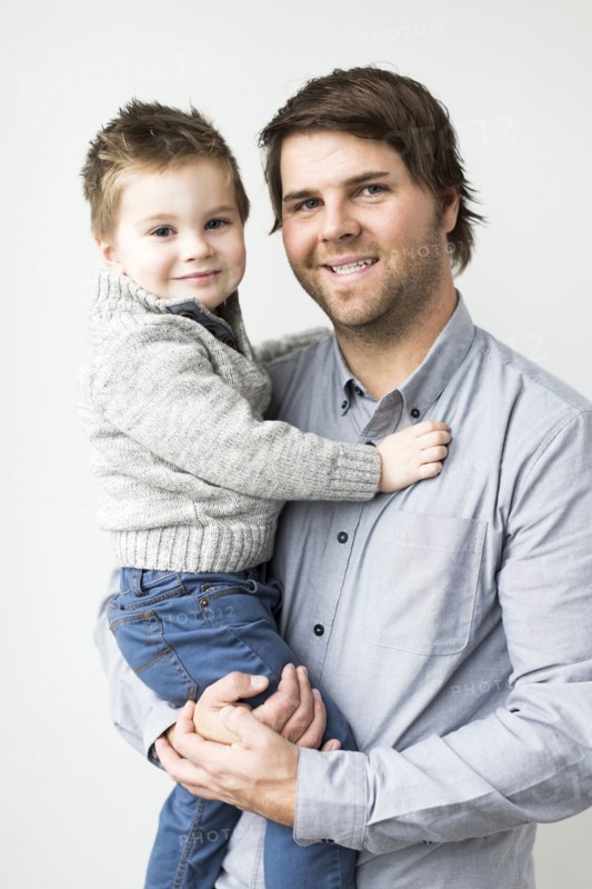 Smiling father holding son (2-3)
