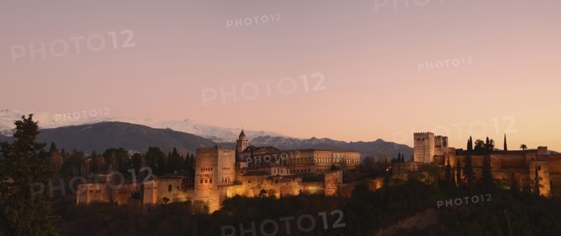 Cityscape with illuminated castle at dusk, pink sky