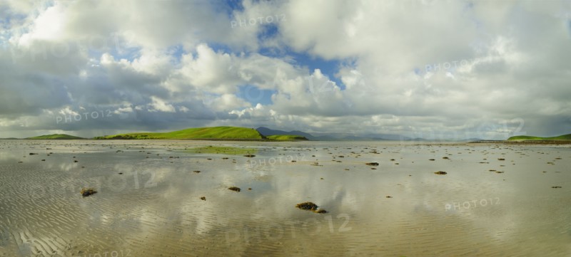Panoramic landscape with water, clouds and hill on horizon