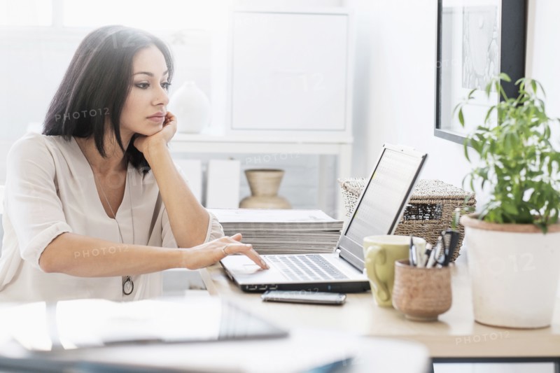 Woman sitting at desk with laptop.
