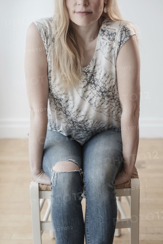 Low-section of woman wearing torn jeans.