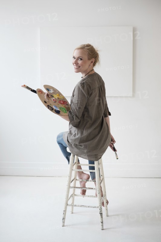 Female artist painting in studio.