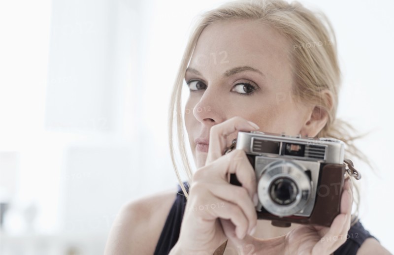 Woman holding digital camera.