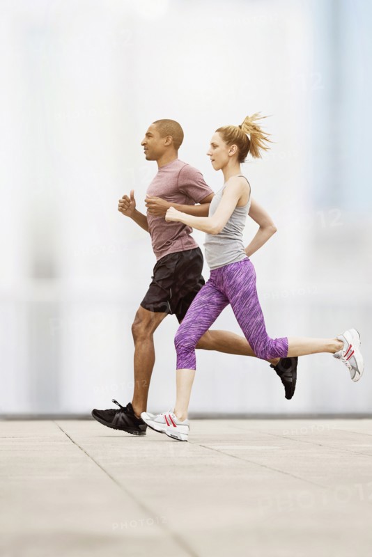Mid adult couple running.