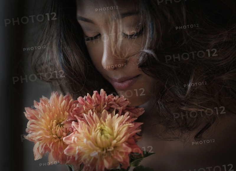 Young woman smelling flowers.