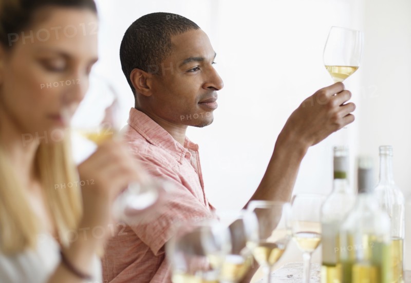 Man and woman tasting white wine.
