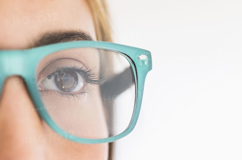 Portrait of young woman wearing eyeglasses in studio.
