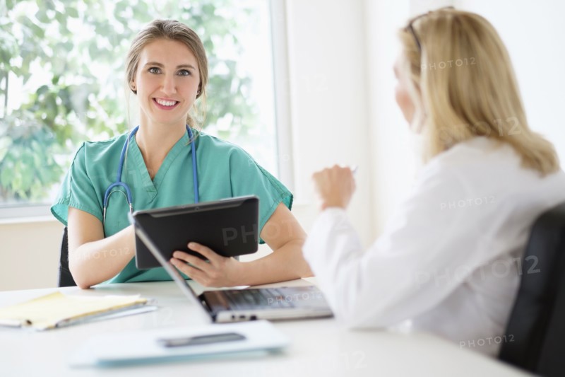 Two female doctors talking in office.