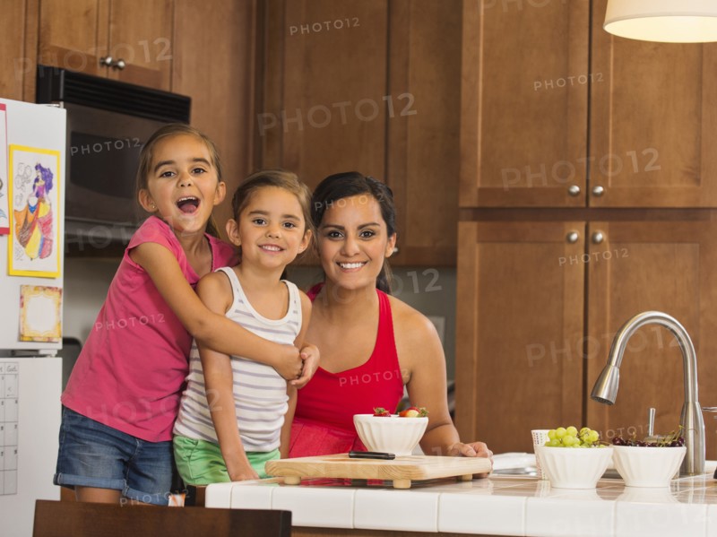 Mother and children (6-7, 8-9) preparing food in kitchen