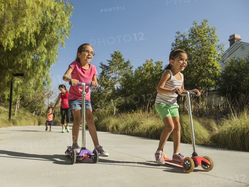 Pregnant mother and children (2-3, 6-7, 8-9) walking outdoors