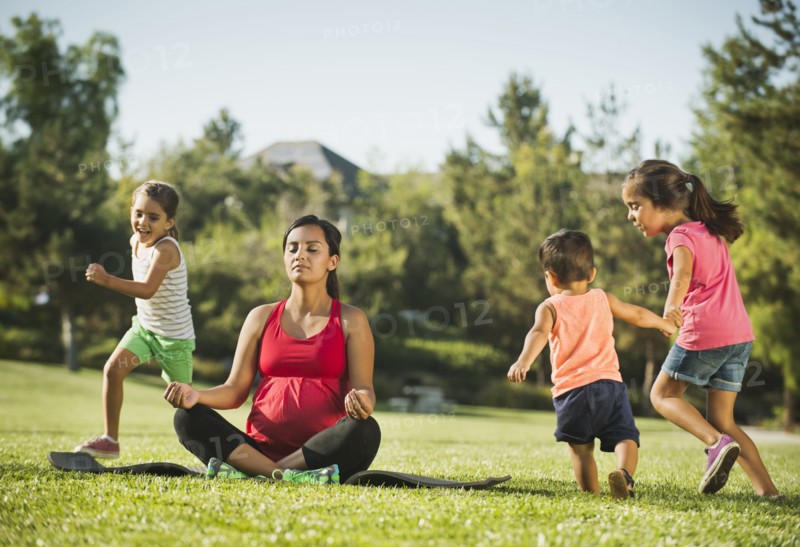 Pregnant mother and children (2-3, 6-7, 8-9) in park