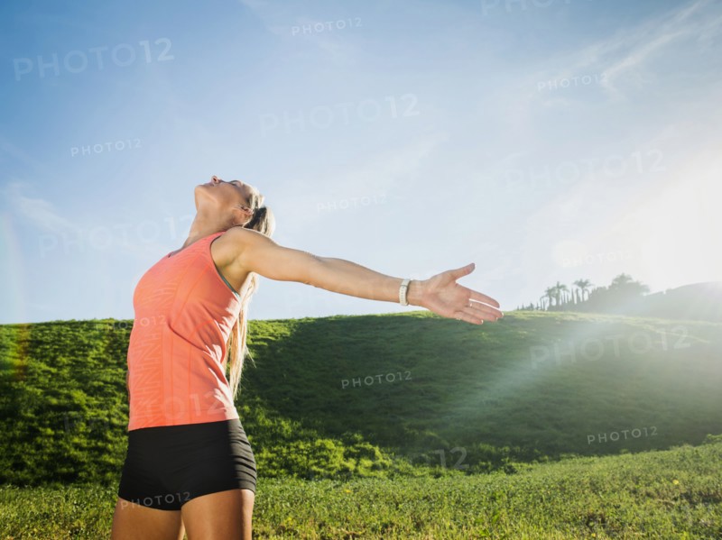 Woman with outstretched arms in field