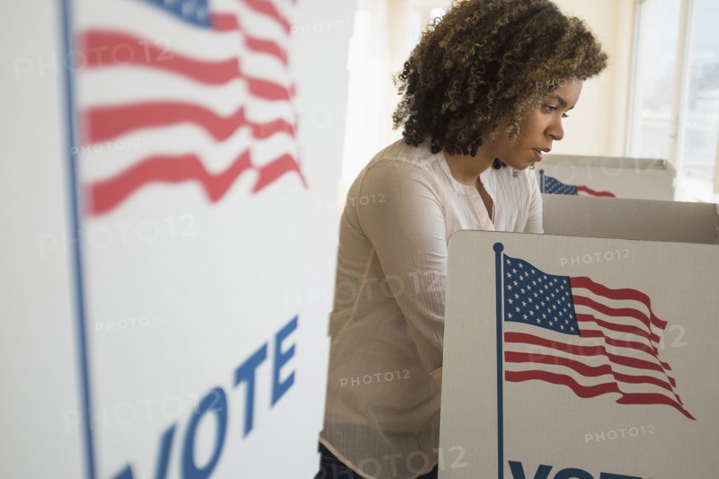 Young woman preparing voting booth.