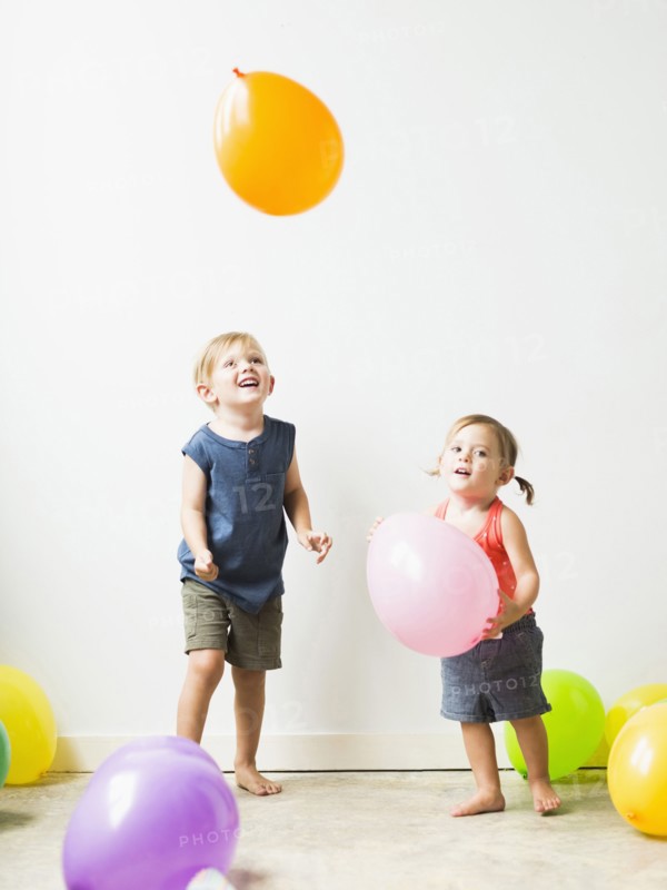 Children (2-3) playing with balloons