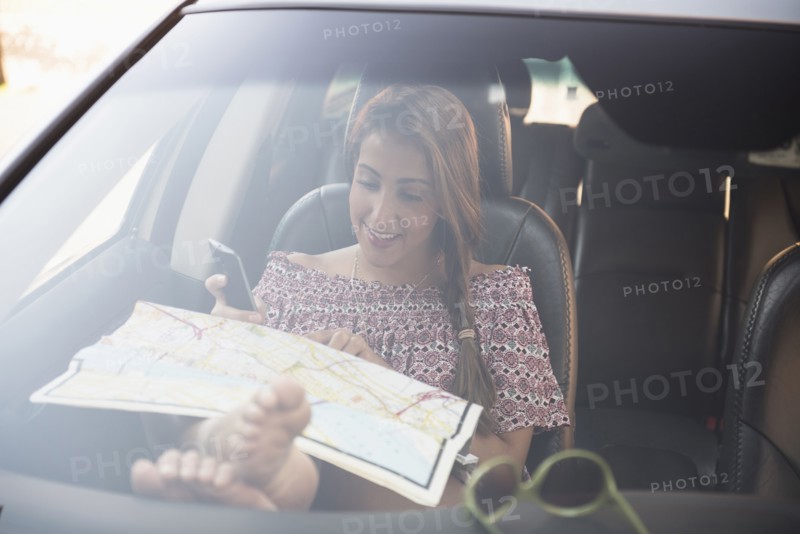 woman sitting in car and looking at map.