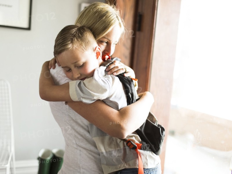 Mother hugging son (6-7)