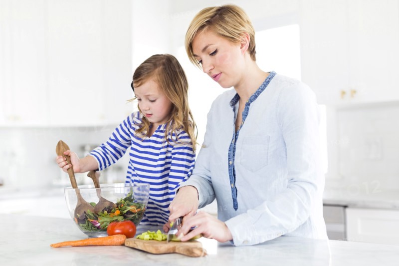 Mother and daughter (4-5) preparing salad