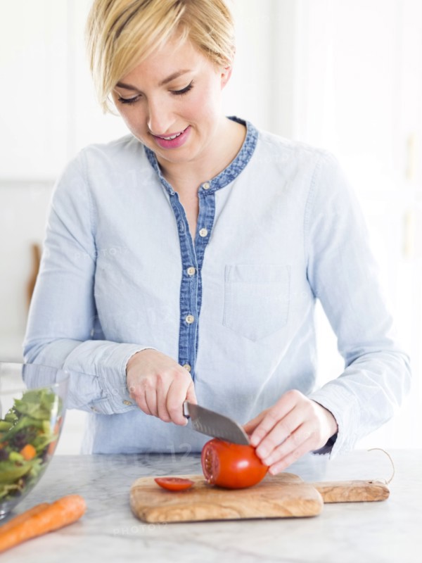 Mid-adult woman preparing salad