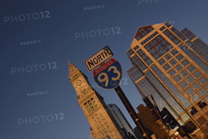 Road sign and office buildings at sunrise