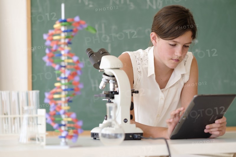 Girl (10-11) using tablet pc in classroom.