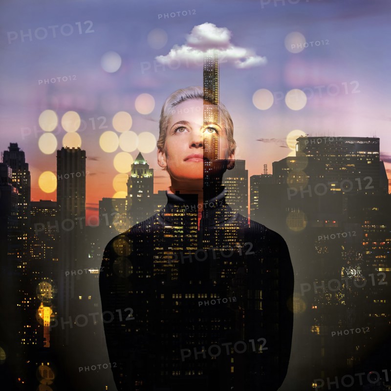 Young woman looking up at night. USA, New York, New York City.